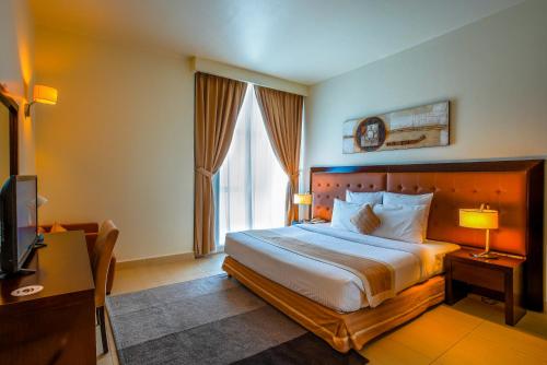 a hotel room with a bed and a television at Imperial Suites Hotel in Doha