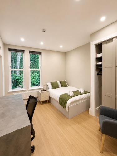 a bedroom with a bed and a table and chairs at 7 Bed, 7 BR Victorian Accom - Sleeps 14 in Walsall