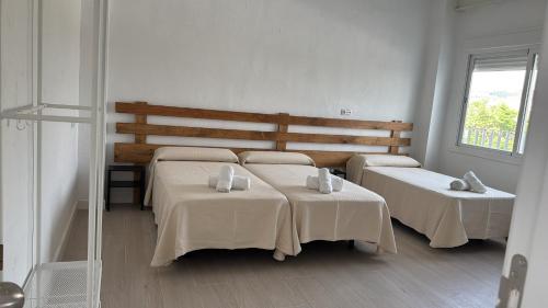 a bedroom with two beds and a mirror at VTAR Casa Carmen en Gilena in Gilena