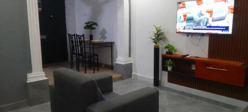 a living room with a tv and a chair at MVH Apartment - Chamber and hall unit in Sunyani