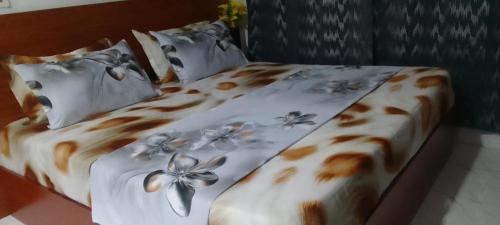 a bedroom with a bed with a flower printed sheets and pillows at MVH Apartment - Chamber and hall unit in Sunyani