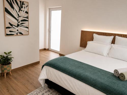 a bedroom with a large bed with a green blanket at Suider Ozias Self Catering in Windhoek