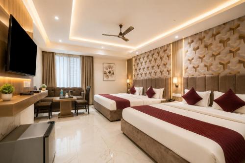 a hotel room with two beds and a television at Hotel Perfectionist- Free Airport Pickup in New Delhi
