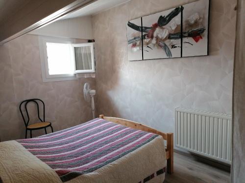 a bedroom with a bed and a picture on the wall at LE CHAMOIS DORT in Die