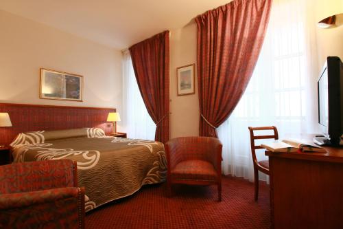 Un pat sau paturi într-o cameră la Hôtel d'Etigny