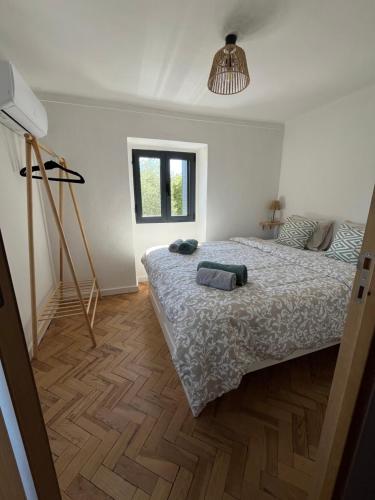 a bedroom with a large bed and a window at Casa do Sol in Pedrógão