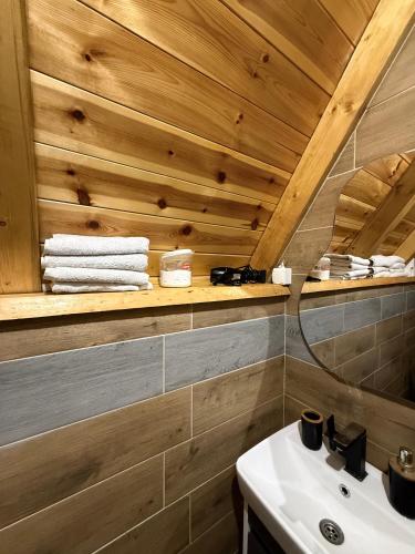 a bathroom with a sink and a wooden ceiling at Nomad Lodge Zminica in Žabljak