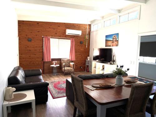 a living room with a table and a couch at Opal St Homestay in Lightning Ridge