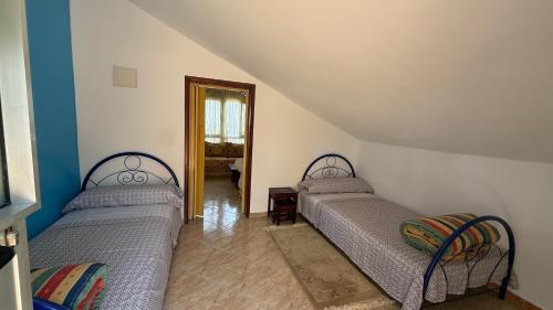 two beds sitting in a room with a hallway at Casa Dina in Ksar es Sghir