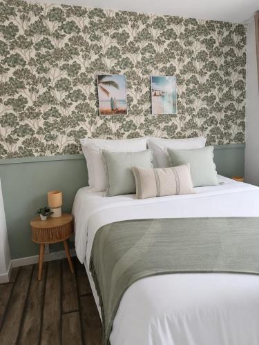 a bedroom with a bed and a wall with wallpaper at L'éclat du phare in Calais