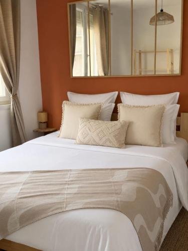 a large bed with white sheets and pillows at L'éclat du phare in Calais