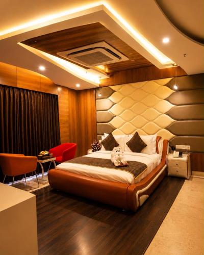 a hotel room with a bed and a table and chairs at Hotel Park Elanza Chennai in Chennai
