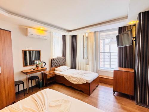 a hotel room with a bed and a desk and a window at Hisar Çeşme Hotel in Istanbul