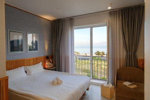 a hotel room with a bed and a large window at Silence hotel in Cholpon-Ata