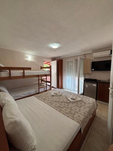 a bedroom with a large bed and a kitchen at Apartmani Teodora in Nov Dojran