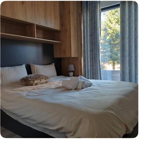 a large bed with two pillows on it with a window at Luxury apartmans in Mavrovo