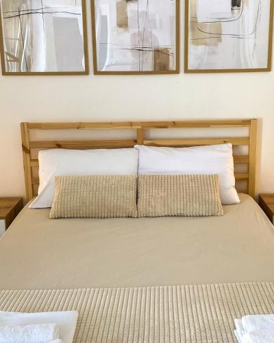 a bed with two pillows and two pictures on the wall at Open Sky Verige Studio in Donja Jošica