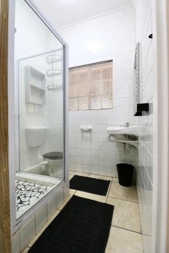 a bathroom with a shower and a sink at Cottage on 10th in Gqeberha