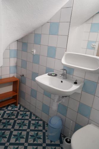 a bathroom with a sink and a toilet at Dom Wypoczynkowy IRMINA in Karwia