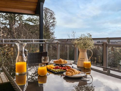 a table with a breakfast of croissants and orange juice at Strathspey Lodge in Duthil