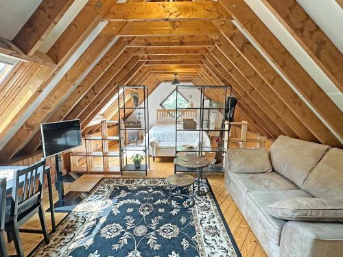 a living room with a couch and a bed at The Loft House in Canford Magna