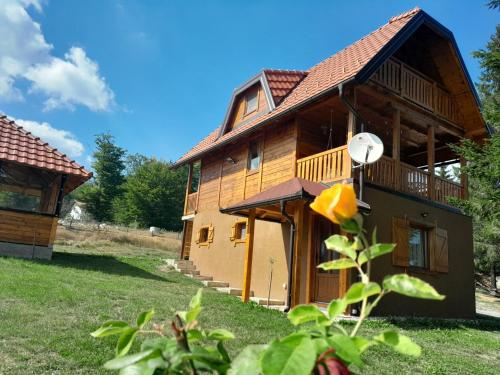 a large wooden house in a yard with a tree at Brvnara Aleksandra Tara Sekulić in Konjska Reka
