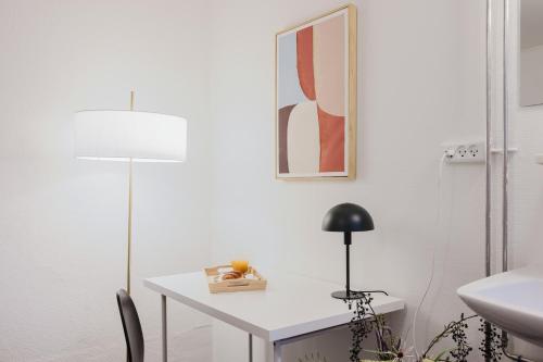 a white bathroom with a desk and a lamp at Nomad Hotel - Frederiksberg in Copenhagen