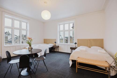 two beds in a room with a table and chairs at Nomad Hotel - Frederiksberg in Copenhagen