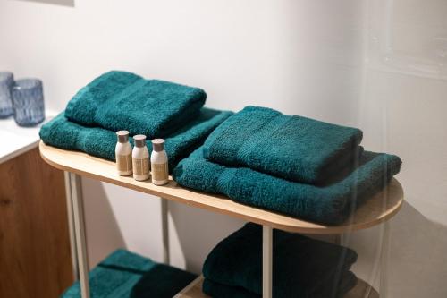 three green towels sitting on a shelf in a bathroom at Klein Lauw 39 in Tongeren