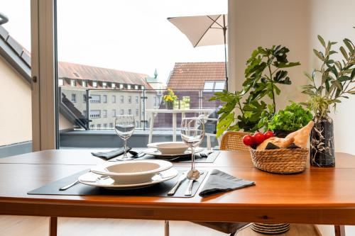ein Tisch mit Tellern und Gläsern und einem Obstkorb in der Unterkunft Soley70 in Neumarkt in der Oberpfalz