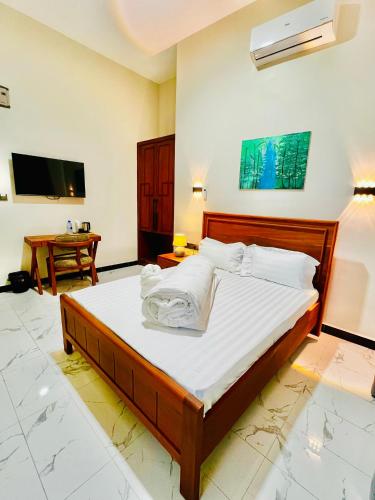 a bedroom with a large bed and a tv at JG Luxury Hotel in Dodoma