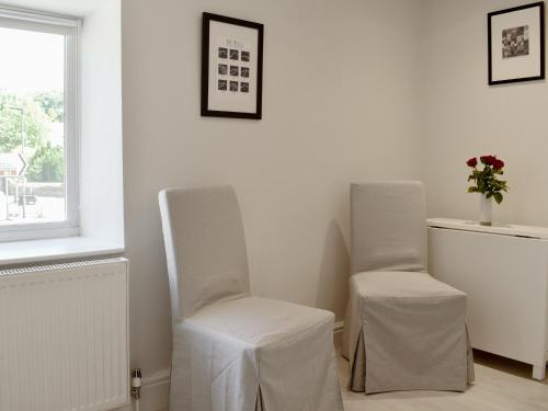 two white chairs in a room with a window at Morton Loft in Hathersage