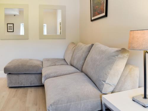 a grey couch in a living room with a lamp at Morton Loft in Hathersage