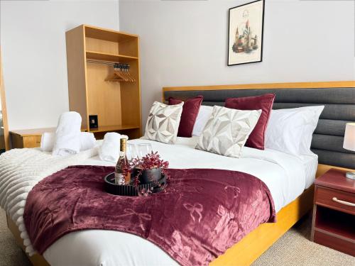 a bedroom with a large bed with a table on it at Maya Hotel in Luton