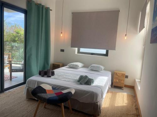 a bedroom with a bed and a large window at Le Frangipanier - Appartement de luxe 3 chambres, 3 sdb, Péreybère in Pereybere