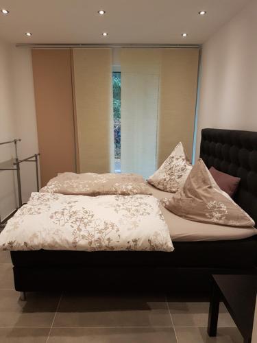a bed with white blankets and pillows on it at Brenzapartments Heidenheim in Heidenheim an der Brenz