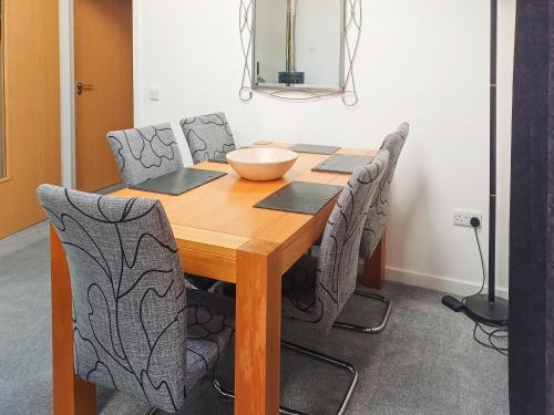 a dining room table with chairs and a bowl on it at Cairn View in Strachan