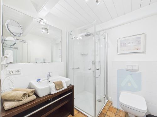 a white bathroom with a shower and a sink at Min aran in Oevenum