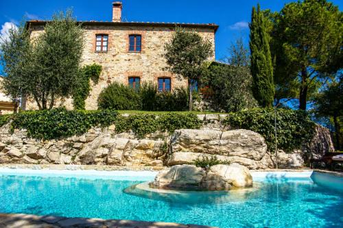a house with a swimming pool in front of a building at Borgo Livernano in Radda in Chianti