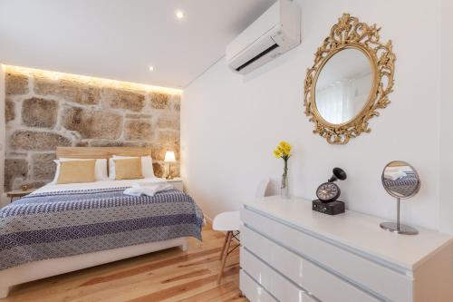 a bedroom with a bed and a mirror at Sendme2Portugal: Loureiro in Porto