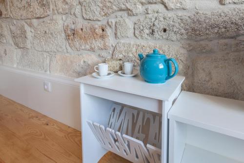 a table with a blue vase on it next to a brick wall at Sendme2Portugal: Loureiro in Porto