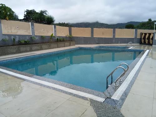 a swimming pool with blue water in a building at THE GK Resort in Ābu Road