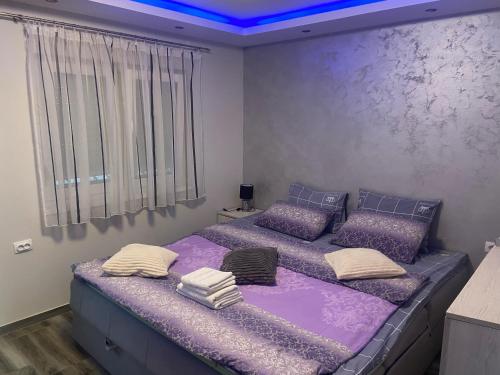 two beds in a room with purple sheets and pillows at Extra Fruske in Vrdnik