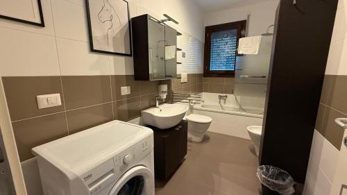 a bathroom with a washing machine and a sink at Aurum Aparthotels Bicocca in Milan