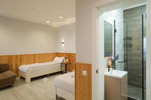 a bedroom with two beds and a sink and a shower at Silence hotel in Cholpon-Ata
