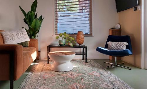 a living room with a couch and a chair at Klein huisje in het centrum in Apeldoorn