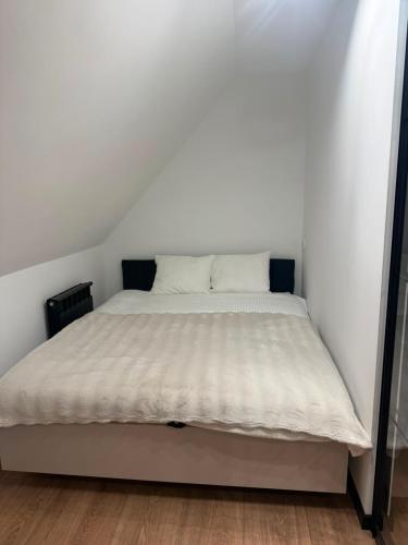 a bed in a white room with a mattress at Apartament Zamkowy Zakątek in Lidzbark Warmiński