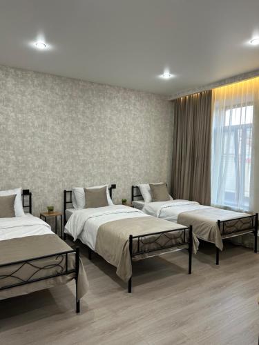 a room with three beds and a window at Linet Apartament in Goris