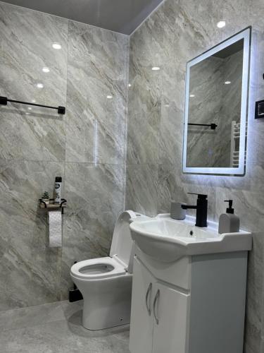 a bathroom with a toilet and a sink and a mirror at Linet Apartament in Goris