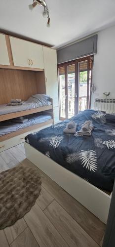a bedroom with two beds with a blue comforter at Rifugio del Piemont in Villaretto